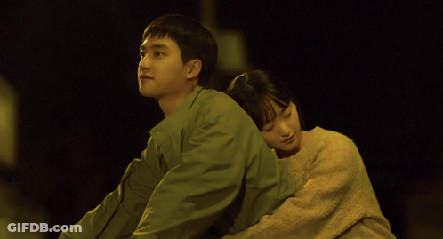 A Man And A Woman Are Hugging Each Other With The Woman 'S Head On The Man 'S Shoulder GIF