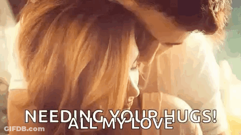 A Man And A Woman Are Hugging Each Other With The Words `` Needing Your Hugs ! '' GIF