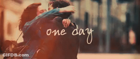 A Man And A Woman Are Hugging Each Other With The Words One Day Written In The Background . GIF