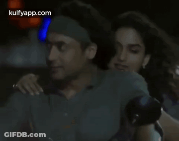 A Man And A Woman Are Hugging In A Dark Room With The Words Kulfyapp.com Visible In The Corner GIF