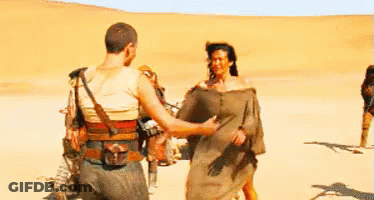 A Man And A Woman Are Hugging In The Middle Of A Desert . GIF