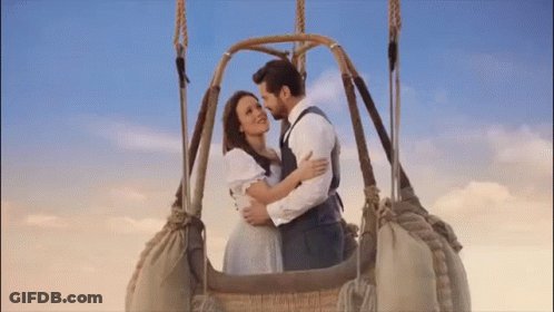 A Man And A Woman Are In A Hot Air Balloon . GIF