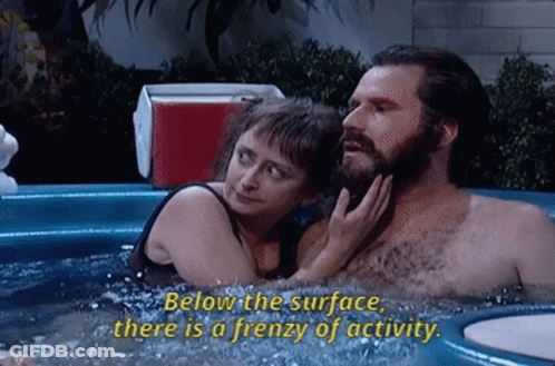 A Man And A Woman Are In A Hot Tub And The Woman Says Below The Surface There Is A Frenzy Of Activity GIF