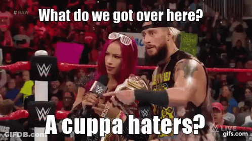 A Man And A Woman Are In A Wrestling Ring And The Man Is Pointing At The Woman Who Is Holding A Trophy . GIF