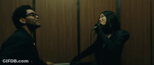 A Man And A Woman Are In An Elevator And The Man Is Smiling GIF