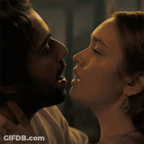 A Man And A Woman Are Kissing And The Woman Is Biting The Man 'S Nose . GIF