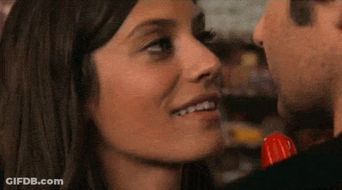 A Man And A Woman Are Kissing And The Woman Is Holding A Lollipop GIF