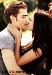 A Man And A Woman Are Kissing And The Woman Is Touching The Man 'S Face GIF