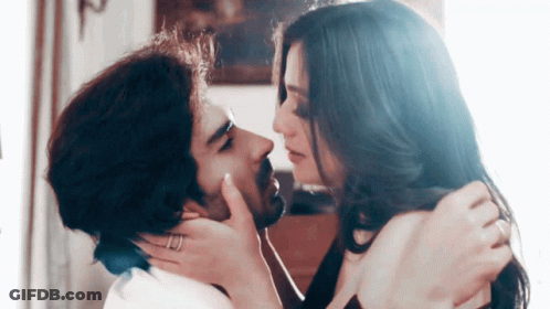 A Man And A Woman Are Kissing And The Woman Is Wearing A Ring On Her Finger GIF