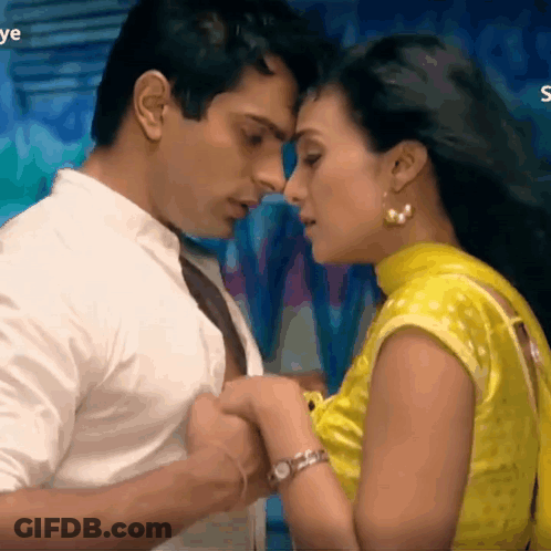 A Man And A Woman Are Kissing And The Woman Is Wearing A Yellow Blouse . GIF