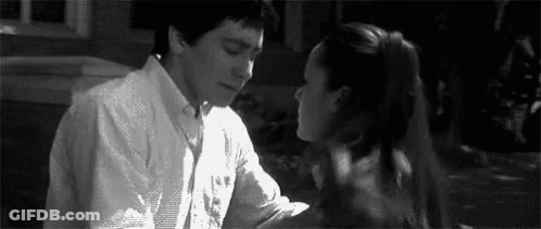 A Man And A Woman Are Kissing Each Other In A Black And White Photo . GIF