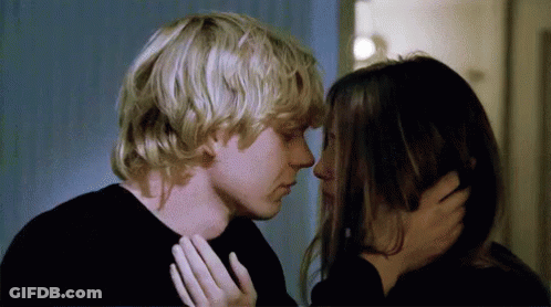 A Man And A Woman Are Kissing Each Other In A Room . GIF