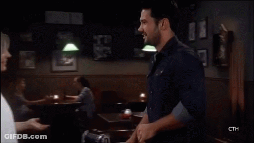 A Man And A Woman Are Kissing Each Other On A Television Screen . GIF