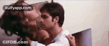 A Man And A Woman Are Kissing Each Other On The Neck . GIF