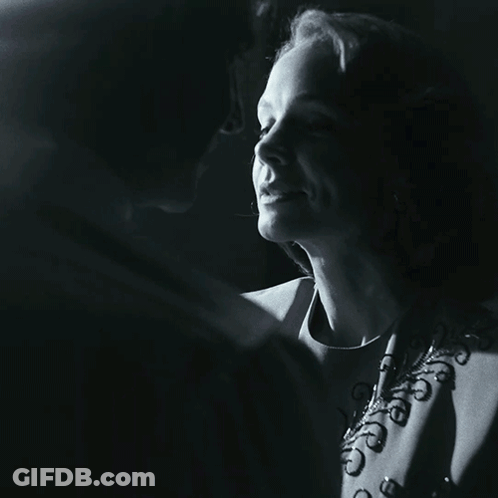 A Man And A Woman Are Kissing In A Black And White Photo GIF
