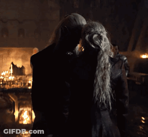 A Man And A Woman Are Kissing In A Dark Room . GIF