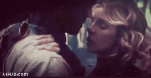 A Man And A Woman Are Kissing In A Dark Room In A Blurry Photo . GIF