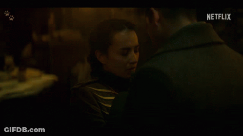 A Man And A Woman Are Kissing In A Dark Room With A Netflix Logo In The Background GIF