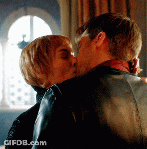 A Man And A Woman Are Kissing In A Room GIF