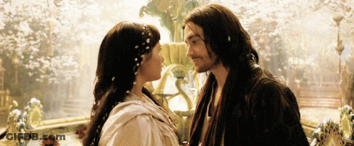 A Man And A Woman Are Kissing In Front Of A Fountain GIF
