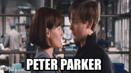 A Man And A Woman Are Kissing In Front Of A Sign That Says Peter Parker On It . GIF