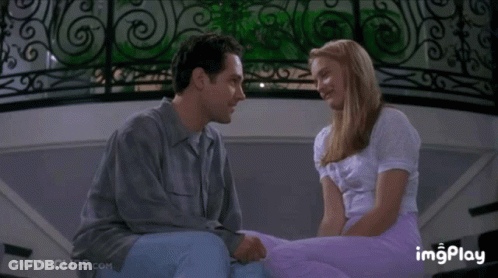 A Man And A Woman Are Kissing In Front Of A Wrought Iron Railing With A Movieclips.com Watermark GIF