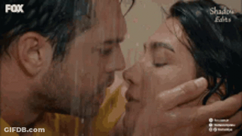 A Man And A Woman Are Kissing In The Rain With Fox Written On The Bottom GIF