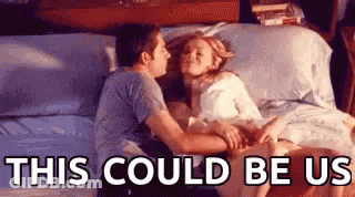 A Man And A Woman Are Kissing On A Bed With The Words `` This Could Be Us '' Above Them . GIF