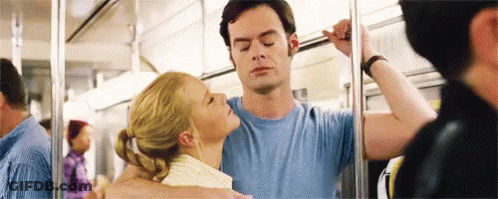 A Man And A Woman Are Kissing On A Subway . GIF