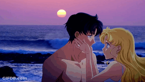 A Man And A Woman Are Kissing On The Beach GIF