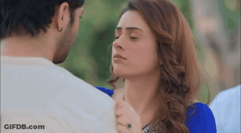 A Man And A Woman Are Kissing With Their Eyes Closed . The Woman Is Wearing A Blue Dress . GIF