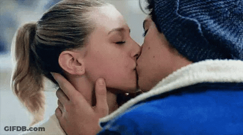 A Man And A Woman Are Kissing With Their Eyes Closed . The Woman Is Wearing A Ponytail . GIF