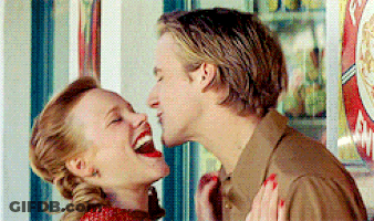 A Man And A Woman Are Laughing And Kissing In Front Of A Vending Machine GIF