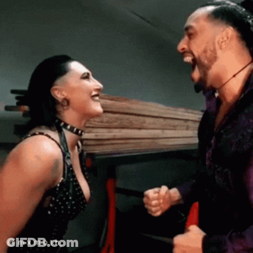 A Man And A Woman Are Laughing At Each Other While Standing Next To Each Other . GIF