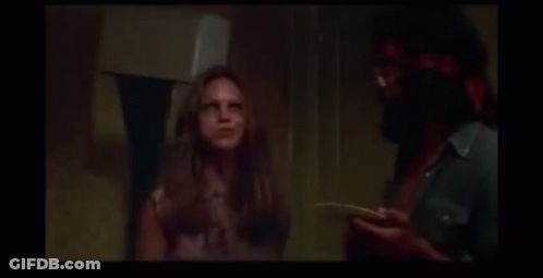 A Man And A Woman Are Laughing In A Dark Room . GIF