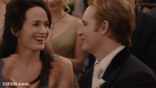 A Man And A Woman Are Laughing Together In A Crowd GIF