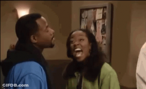 Man And Woman Laughing In Front Of Bulletin Board GIF
