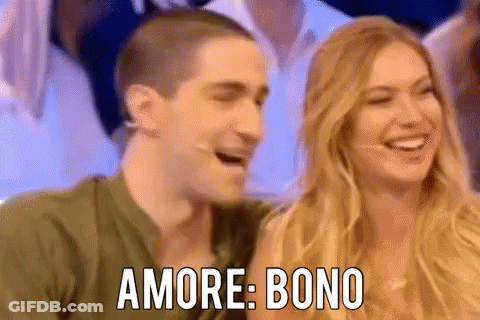 A Man And A Woman Are Laughing Together On A Stage And The Man Is Wearing A Microphone . GIF