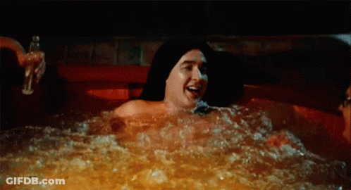 A Man And A Woman Are Laying In A Hot Tub . GIF