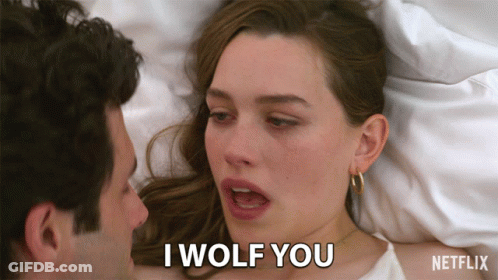 A Man And A Woman Are Laying In Bed And The Woman Is Saying I Wolf You GIF