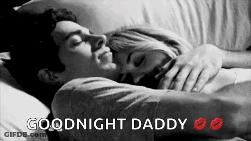 A Man And A Woman Are Laying In Bed Hugging And Kissing Each Other . GIF