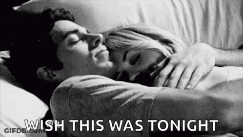 A Man And A Woman Are Laying In Bed Hugging Each Other And The Man Is Saying `` Wish This Was Tonight '' . GIF