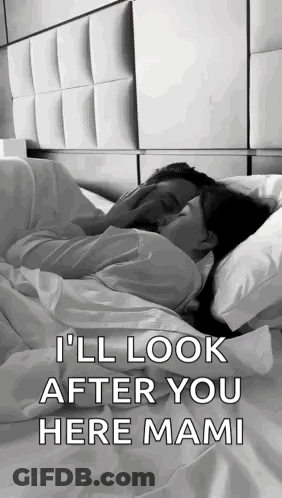 A Man And A Woman Are Laying In Bed Kissing . GIF