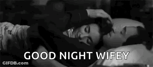 A Man And A Woman Are Laying In Bed Together And The Man Is Petting The Woman 'S Head . GIF