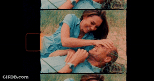 A Man And A Woman Are Laying In The Grass GIF