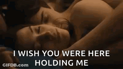A Man And A Woman Are Laying Next To Each Other In Bed . GIF