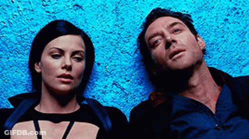 A Man And A Woman Are Laying Next To Each Other On A Blue Surface GIF