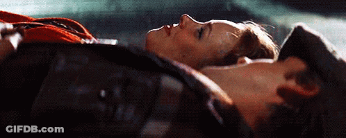 A Man And A Woman Are Laying Next To Each Other On The Floor . GIF