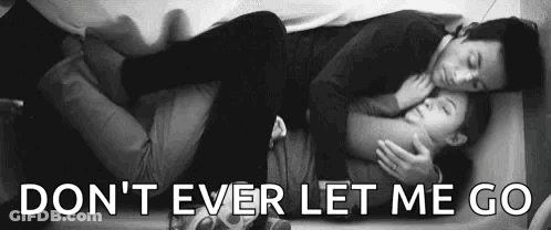 A Man And A Woman Are Laying On A Bed And Hugging . GIF