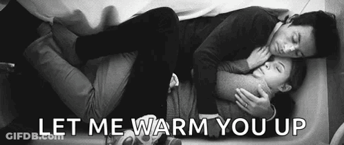 A Man And A Woman Are Laying On A Bed And Hugging . GIF